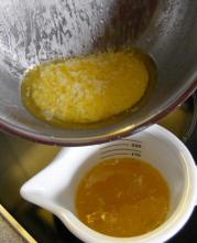 The leftover solids from making ghee, with a cup of ghee below.